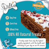 A promotional graphic for dog treats from The Lazy Dog Candy Co., featuring a large slice of chocolate brown cake with white frosting and dried fruit pieces on a teal background.